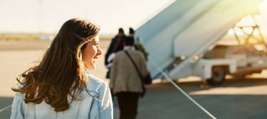 Eine junge Frau auf dem Weg zum Flugzeug