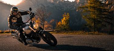 Motorradfahrer im Sonnenuntergang in den Bergen