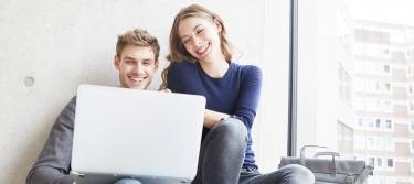 Mann und Frau schauen gemeinsam auf einen Laptop